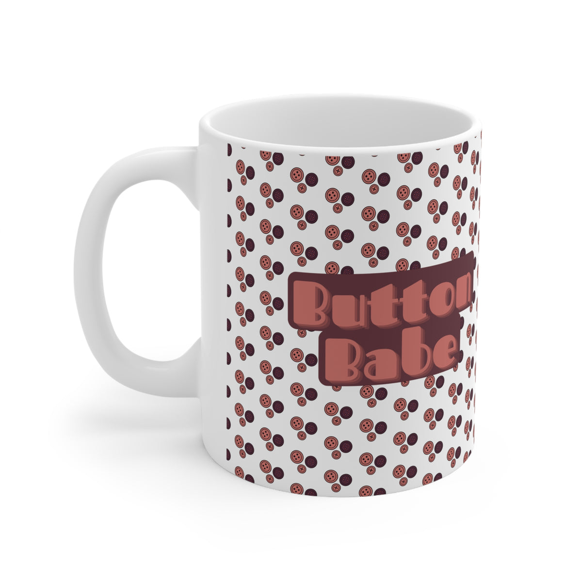 A white ceramic coffee mug featuring a repeating pattern of small brown and dark brown buttons, with a central brown rectangular patch that reads 'Button Babe' in a pinkish-brown retro font.